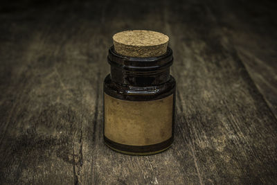 Close-up of antique bottle with cork on table