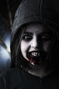 Portrait of vampire girl with artificial blood on mouth