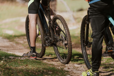Low section of man riding bicycle on field