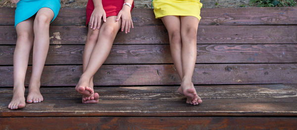 Low section of women standing on wooden floor