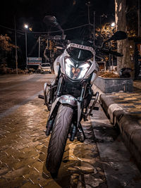 Bicycle parked on street in city at night