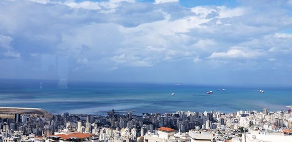 High angle view of buildings by sea against sky