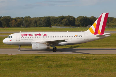 Airplane on airport runway against sky