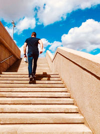 Low angle view of man on staircase against sky