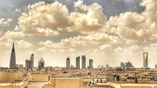 Modern cityscape against cloudy sky