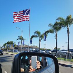 Reflection of man on side-view mirror of car