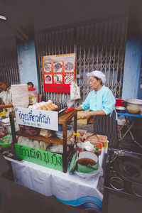 Woman with vegetables for sale at store