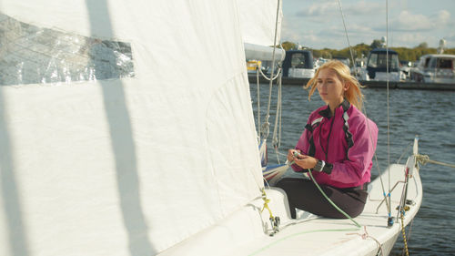 Young woman sitting on boat in water