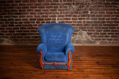 Close-up of chair against brick wall