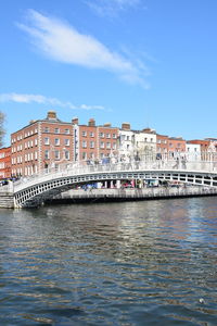 Arch bridge over river against buildings in city