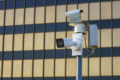 Surveillance cameras in the city in front of a modern administrative building.