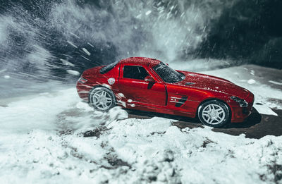 Red toy car on snow covered landscape