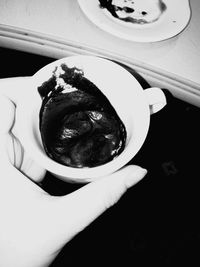 Close-up of hand holding ice cream in plate