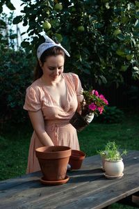 Woman in flower pot on table in yard