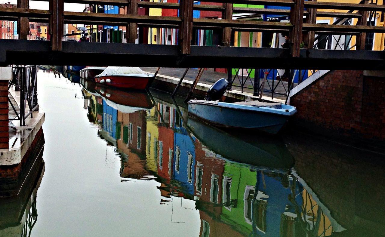 architecture, built structure, building exterior, water, moored, nautical vessel, reflection, in a row, boat, canal, waterfront, residential structure, residential building, high angle view, day, building, transportation, city, window, no people