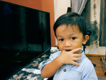 Portrait of cute boy looking away at home