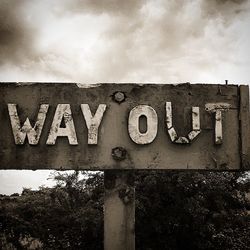 Low angle view of sign board against sky