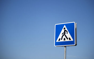 Road sign pedestrian crossing on a background of blue sky