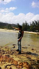 Full length of boy standing on lake against sky