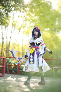 Rear view of woman wearing traditional clothing standing against trees