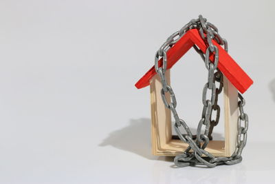 Close-up of chain hanging on table against white background