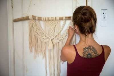 Rear view of woman standing against wall