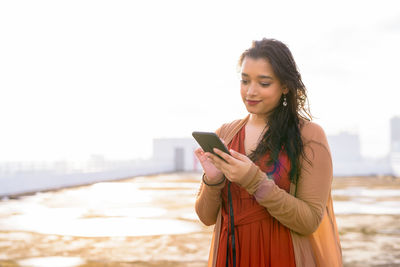 Young woman using mobile phone outdoors