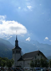 Church by buildings against sky