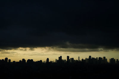 Silhouette buildings against sky during sunset