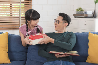 Rear view of man and woman sitting at home