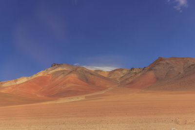 Scenic view of desert against blue sky