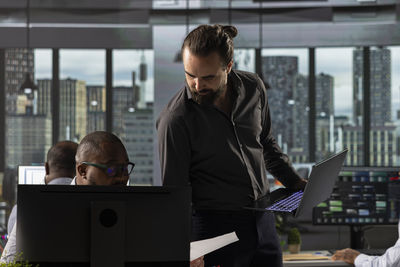 Side view of businessman using laptop at office
