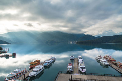 High angle view of boats moored at harbor against sky