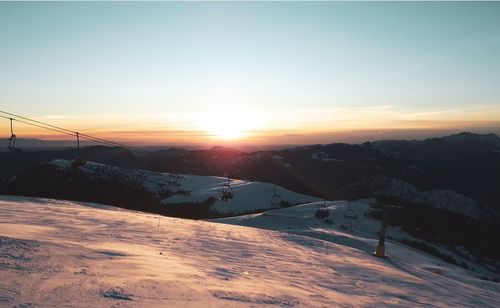 Scenic view of snow covered mountains against sky during sunset