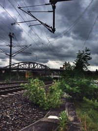 Railroad tracks against cloudy sky