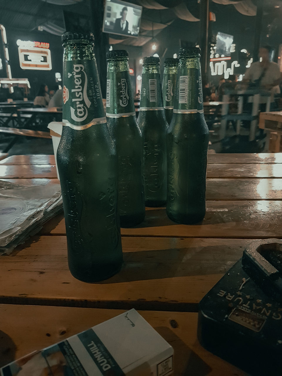 CLOSE-UP OF BEER BOTTLES ON TABLE