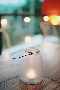 Close-up of illuminated light bulb on table