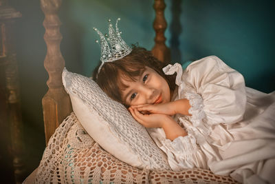 Portrait of cute girl lying on bed at home