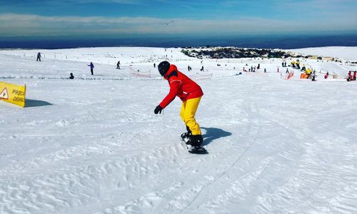 Man snowboarding on snow covered land