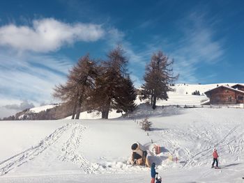 Rear view of people on snowcapped mountain against sky