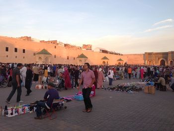 People at market by bab mansour against sky