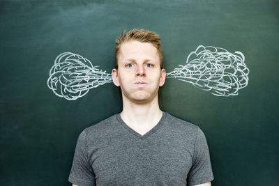 Portrait of young man standing at home