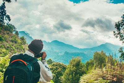 Man standing on mountain against sky