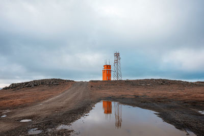 Lighthouse on land against sky