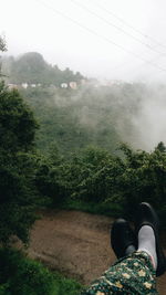 Low section of man on landscape against sky