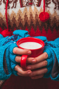 Midsection of woman holding milk in cup