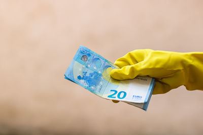 Close-up of hand holding yellow paper