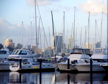 Boats moored at harbor against sky