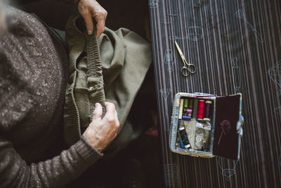 Senior woman with sewing kit, top view