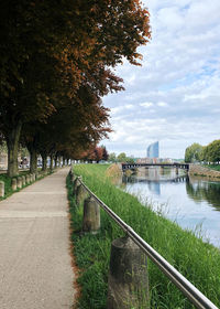 Footpath by river against sky